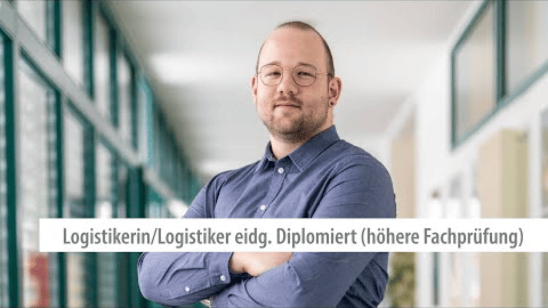 Eine Person mit Brille und Bart steht selbstbewusst mit verschränkten Armen in einem hellen Hausflur. Der Text auf Deutsch lautet: Logistikerin/Logistiker eidg. diplomiert (höhere Fachprüfung).