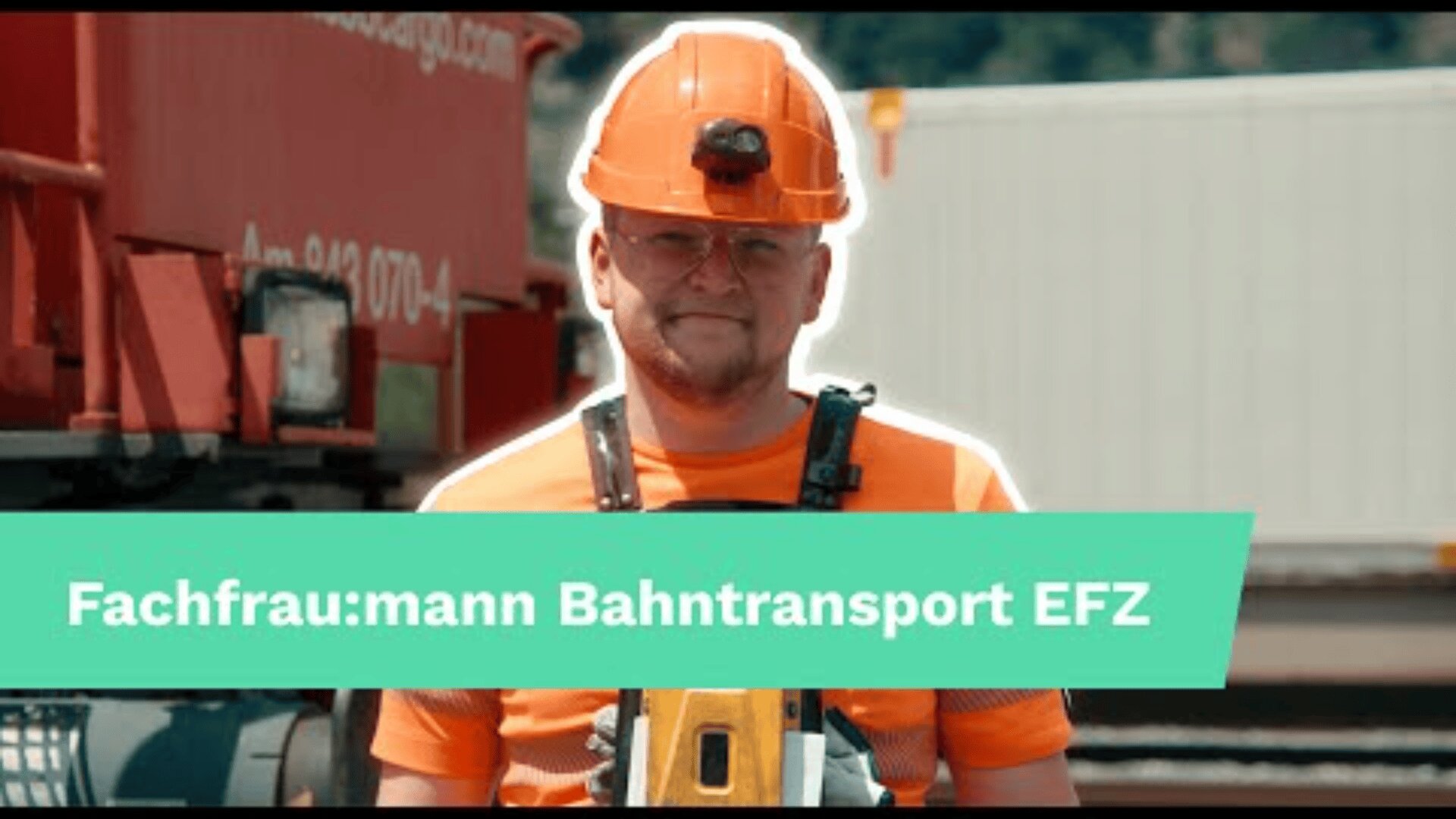 Ein Eisenbahner mit orangefarbener Sicherheitsweste und Helm steht im Freien neben einem roten Zug und einem weissen Container. Unten ist ein grünes Banner mit der Aufschrift Fachfrau:mann Bahntransport EFZ eingeblendet.