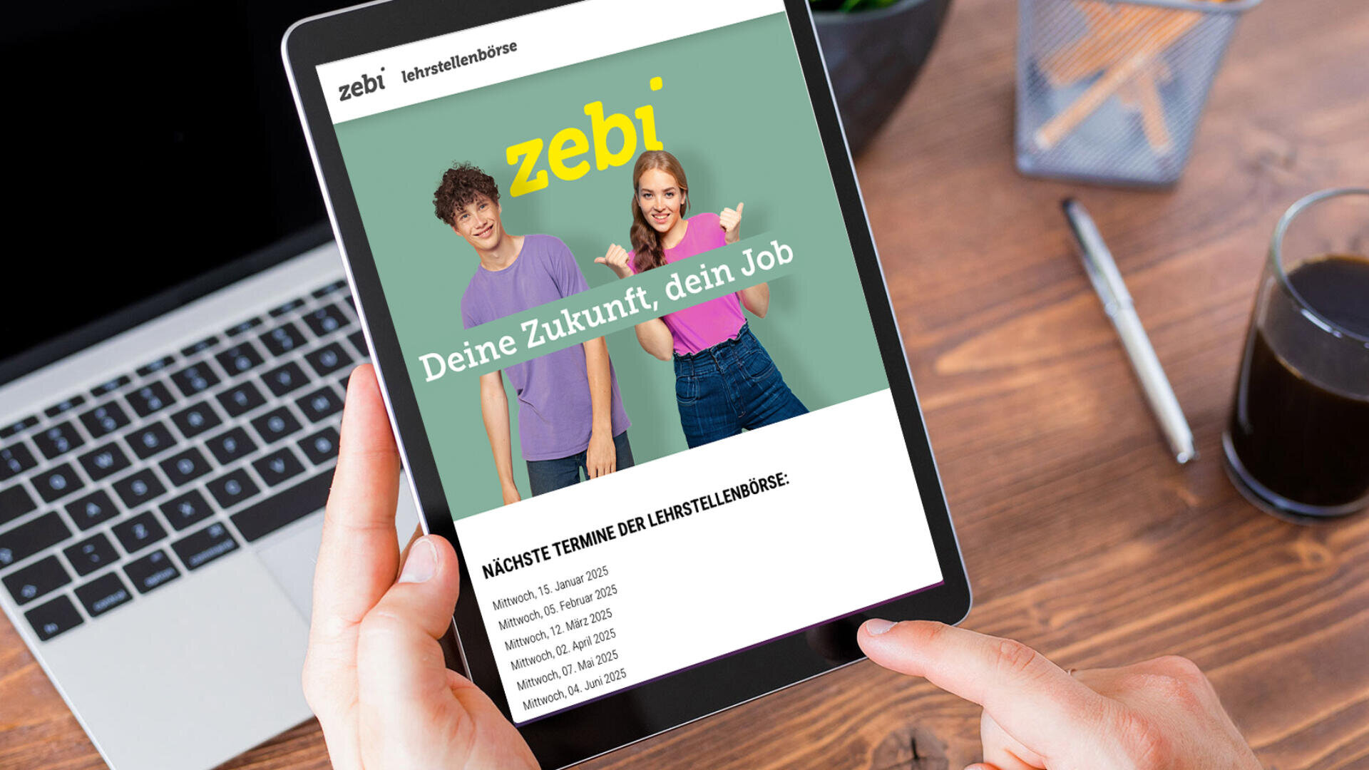 Eine Person hält ein Tablet in der Hand, auf dem eine Website von Zebi mit einem jungen Mann und einer Frau und dem Text Deine Zukunft, dein Job abgebildet ist. Auf dem Tisch im Hintergrund stehen ein Laptop, ein Notizbuch, ein Stift und ein Getränk.