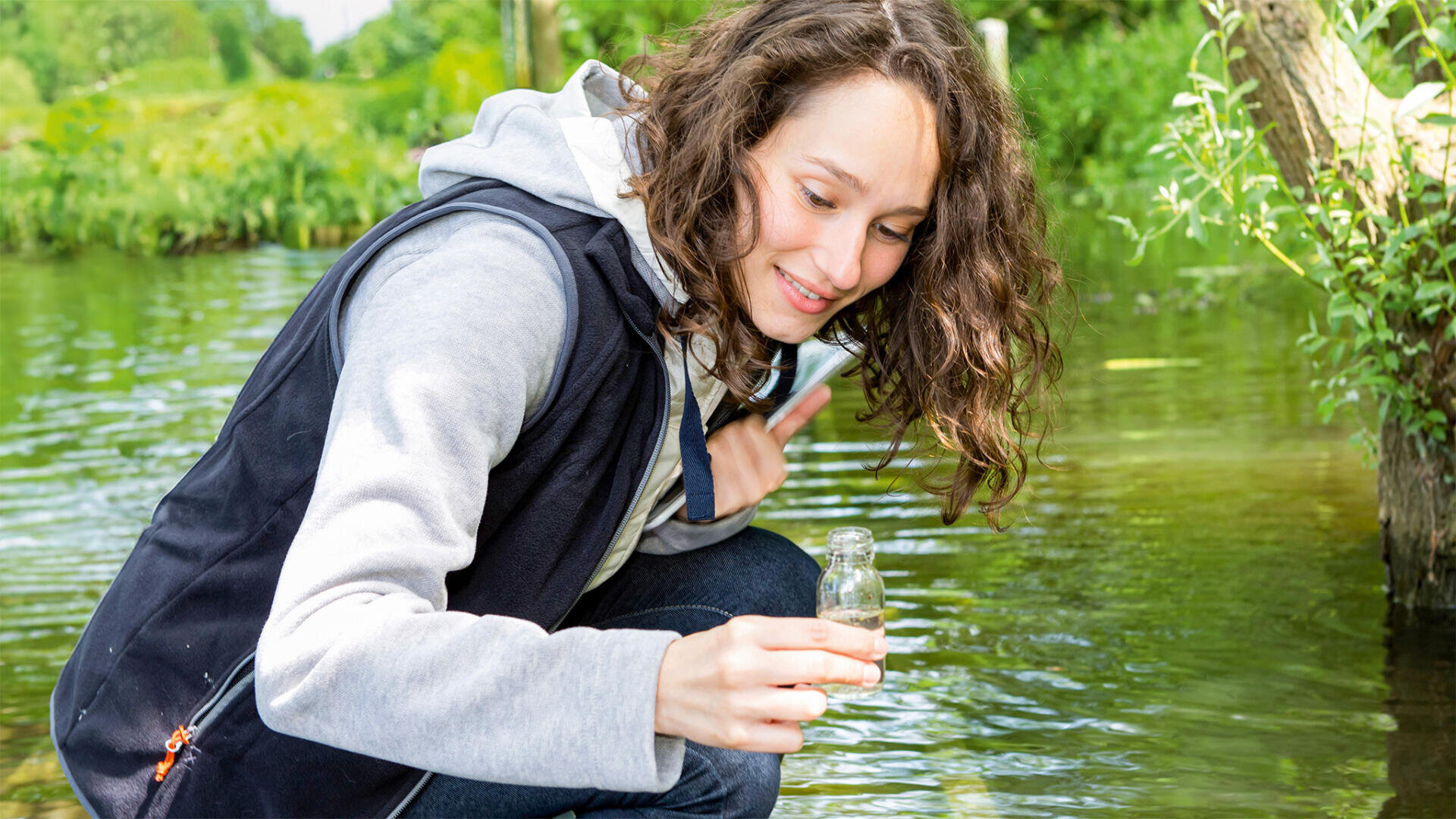 Eine Frau mit einer kleinen Wasserflasche in der Hand.