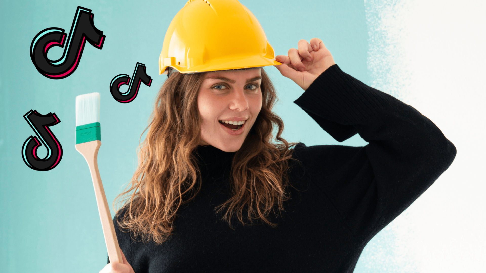Eine lächelnde Frau mit einem gelben Schutzhelm hält einen Pinsel in der Hand und steht vor einer halb bemalten Wand. In ihrer Nähe werden TikTok-Logos bearbeitet, was auf ein in den sozialen Medien geteiltes Heimwerkerprojekt hindeutet.