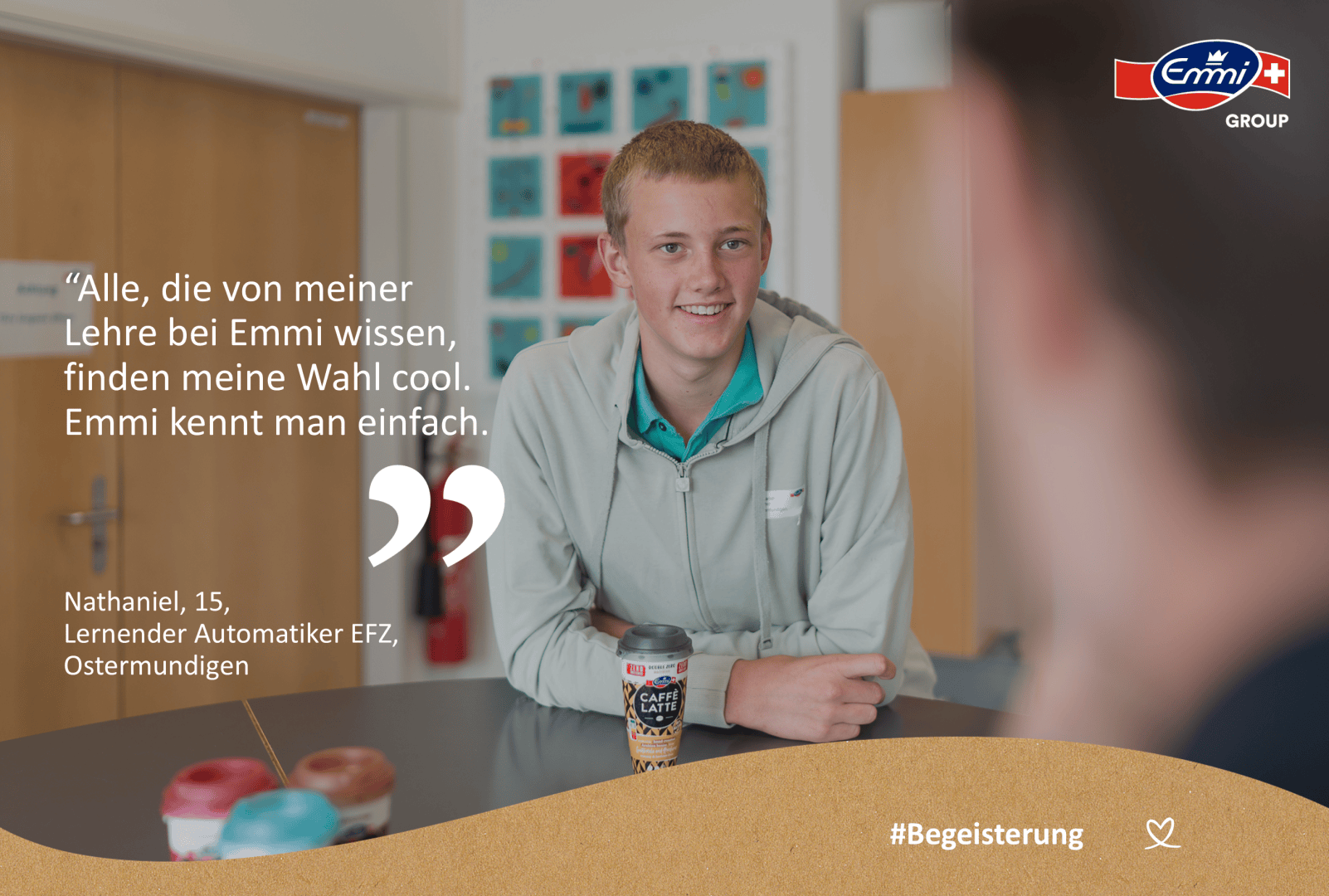 Ein lächelnder Jugendlicher in grüner Jacke sitzt an einem Tisch mit Emmi Jogurtprodukten. Ein deutscher Text zitiert ihn über seine Ausbildung. Das Logo der Emmi Gruppe ist oben rechts zu sehen. Am unteren Rand steht #Begeisterung.