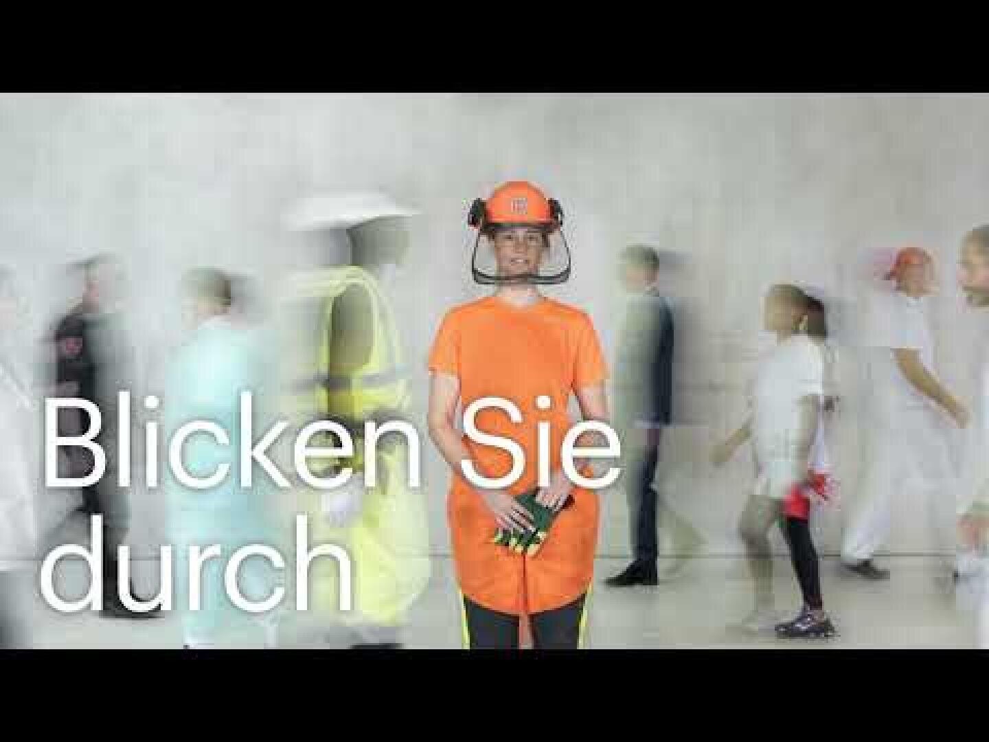 Eine Person in orangefarbener Schutzkleidung und Helm steht still und hält eine Schutzbrille, während unscharfe Menschen vorbeigehen. Auf der linken Seite des Bildes steht in weißer Schrift "Blicken Sie durch".
