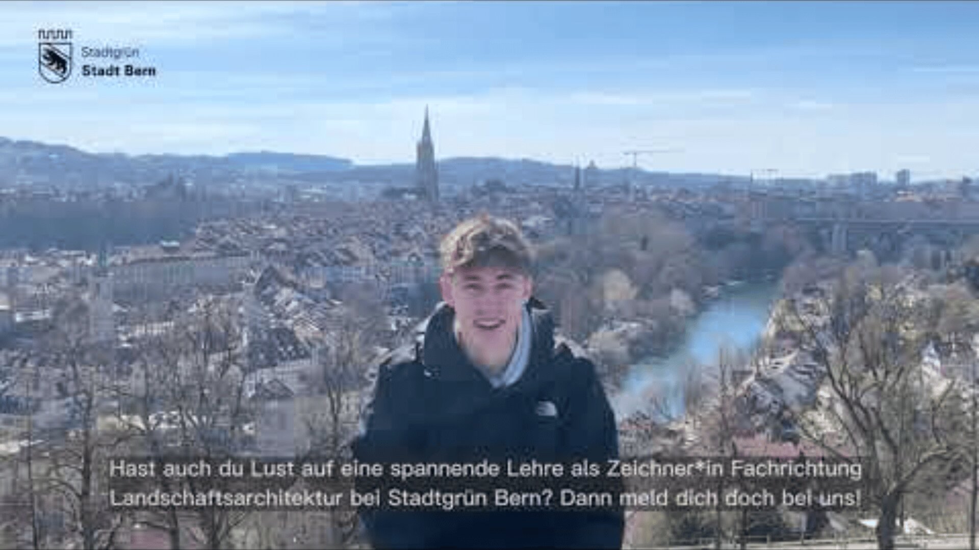 Ein junger Mensch steht lächelnd im Freien mit dem Stadtbild von Bern, Schweiz, im Hintergrund. Der deutsche Text wirbt für eine Ausbildung zum Landschaftsarchitekten bei Stadtgrün Bern.