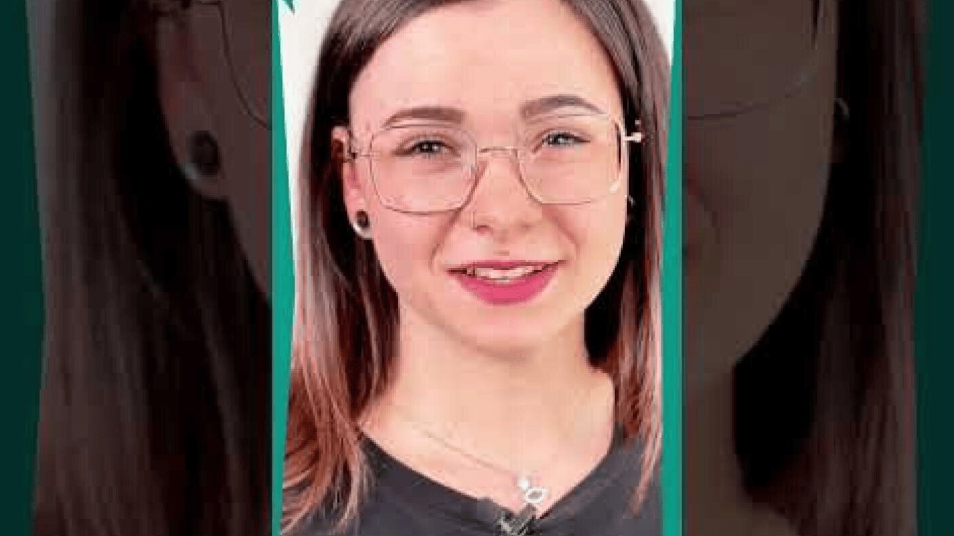 Eine junge Frau mit glattem braunem Haar, einer großen Brille und einem schwarzen Hemd lächelt in die Kamera. Sie trägt Ohrringe und eine Halskette. Der Hintergrund ist in einem dunklen Teeton gehalten.